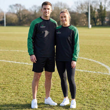 Load image into Gallery viewer, Two people wearing black and green Scorpion Sports Pro Drill Tops on a grass sports field.
