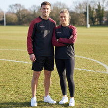 Load image into Gallery viewer, Black and Maroon Pro Drill Tops being worn by 2 models standing on a sports field.
