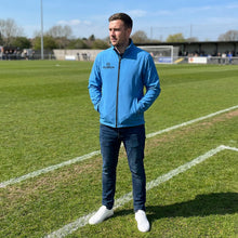 Load image into Gallery viewer, Cyan Softshell Jacket photo on a model wearing as teamwear at a sports event.
