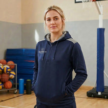 Load image into Gallery viewer, School Teacher standing in a schools sports hall wearing a navy and grey Scorpion Sports Heritage Hoodie.
